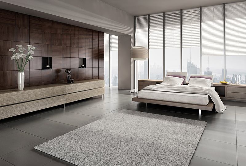 A bedroom with a large window and a white rug.